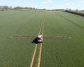 Crop sprayer in field aerial view - Captured by a licensed UAV operator with a permission for aerial work.